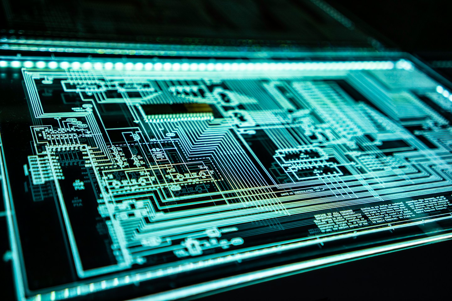 Glowing futuristic circuit board with intricate lines and components.
